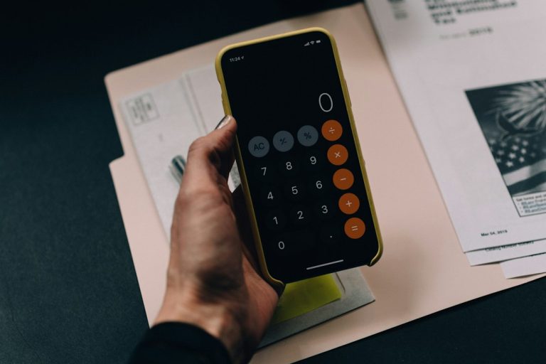 Person using a smartphone calculator to review figures and promotional terms